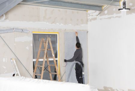 Unsichtbarer Komfort: Montage der E-NERGY CARBON FLEECE Heizfolie direkt an der Wand des Aufenthaltsraums
